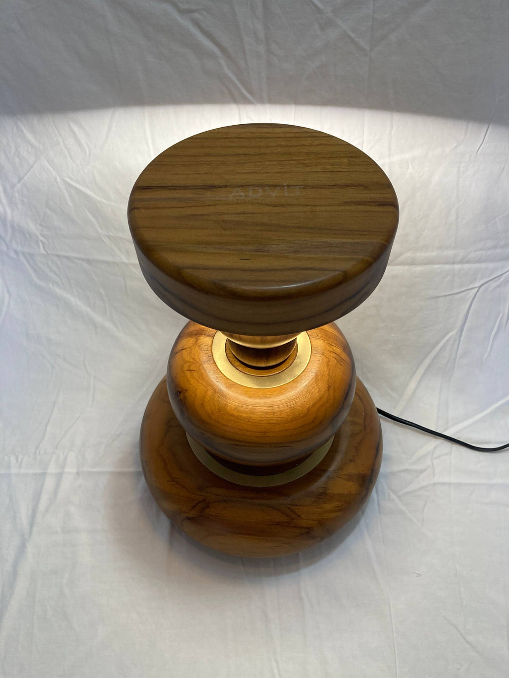 Wooden lamp with a cylindrical design on a white background - aikya table lamp by advit design lab - made of teak wood and brass rings