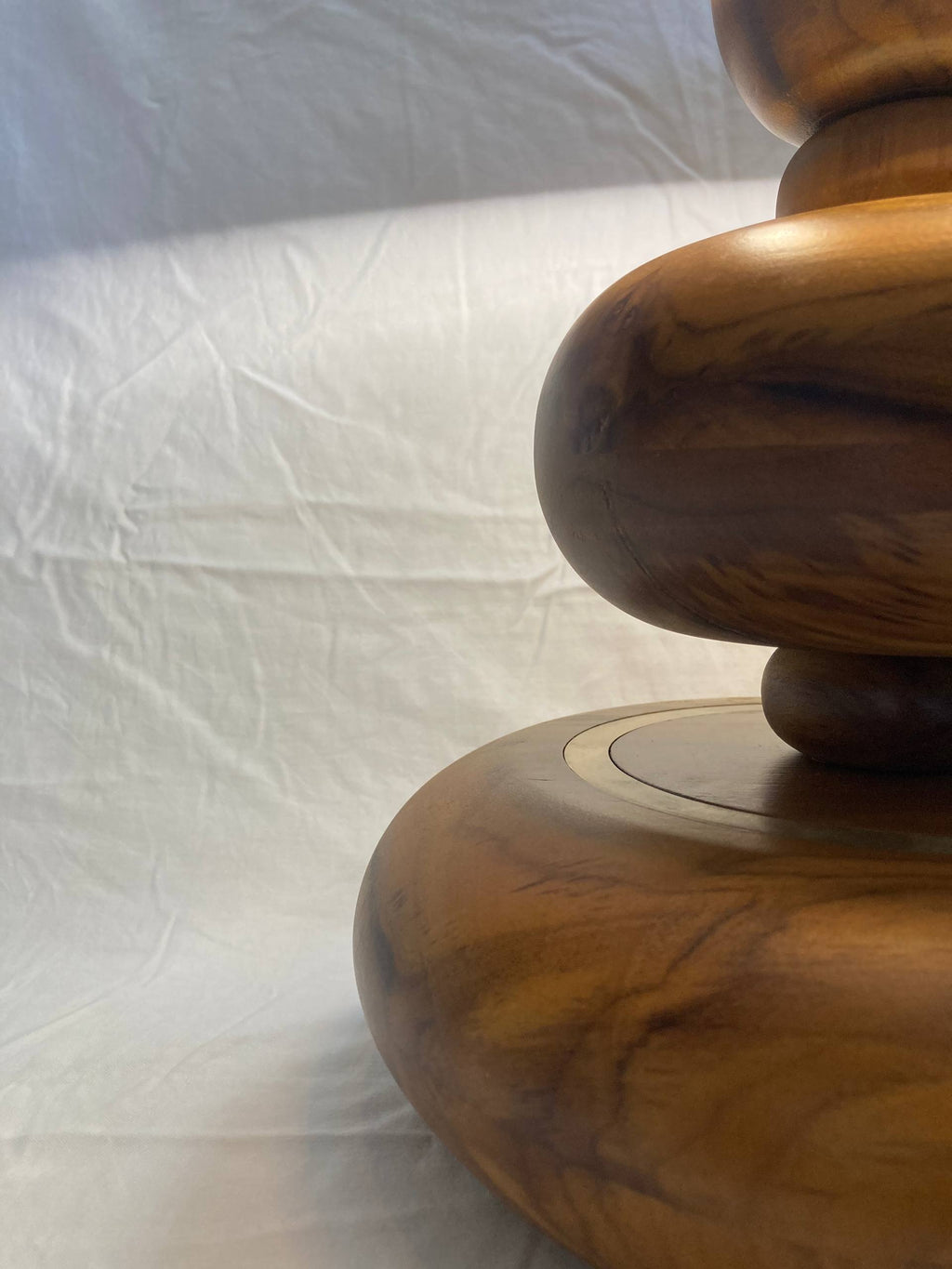 Wooden lamp with a textured surface on a white background - aikya table lamp by advit design lab - made of teak wood and brass rings